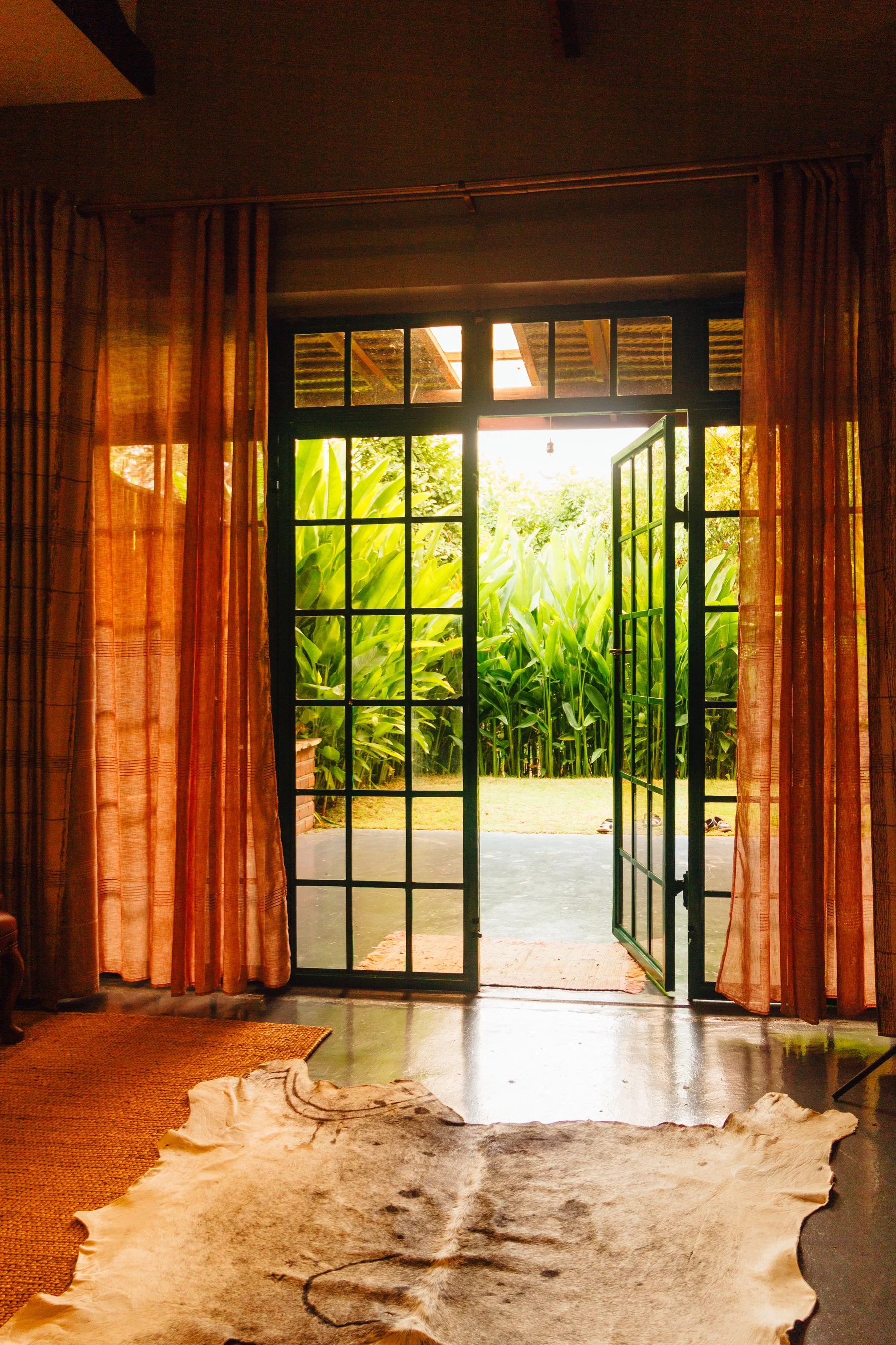 Glass patio doors opening onto a lush green garden